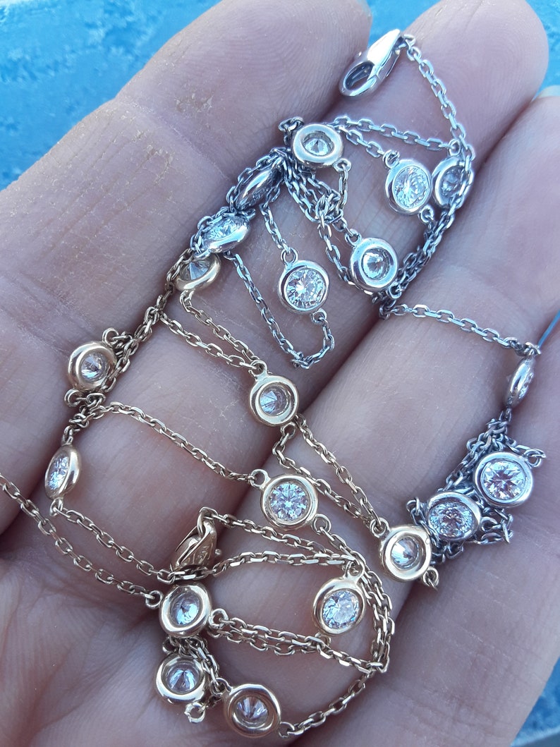 May include: Two delicate necklaces with round diamond accents. One necklace is gold and the other is silver.