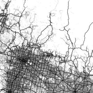 May include: Black and white aerial map of a city with a grid pattern of streets and roads. The map shows a dense urban area with a network of highways and smaller roads.