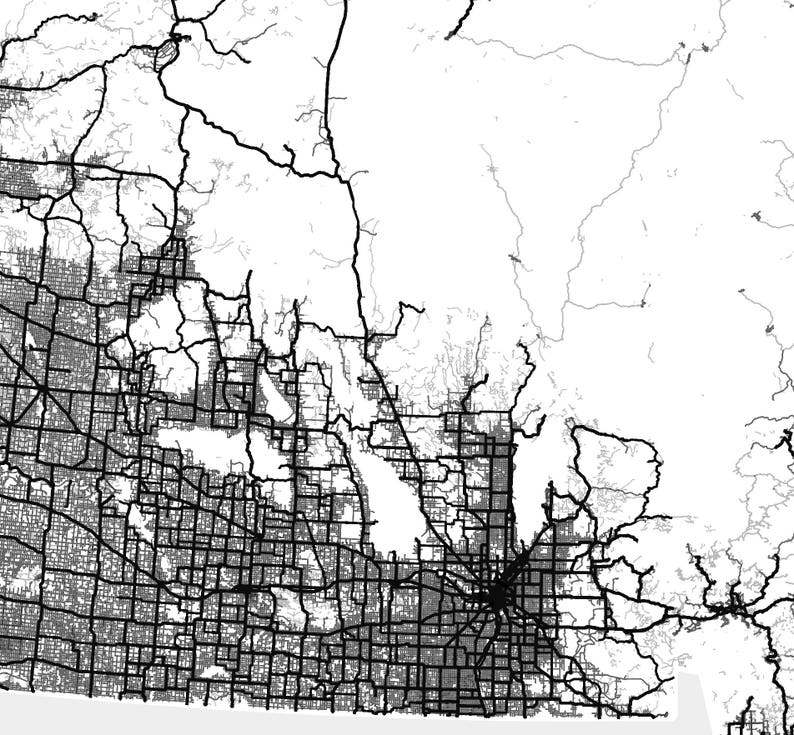 May include: Black and white map of a city with a grid pattern of streets and roads. The map shows a large urban area with surrounding suburbs and rural areas.