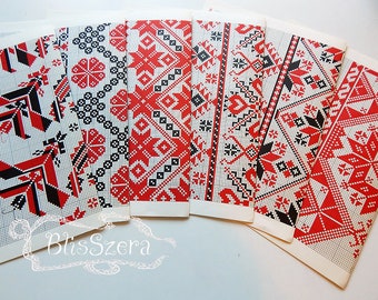 Peut inclure: Ensemble de cartes rectangulaires avec des motifs géométriques complexes rouges, noirs et blancs. Les dessins présentent des motifs floraux et étoilés, sur un fond quadrillé. Les cartes sont disposées en éventail, mettant en valeur la variété des motifs.