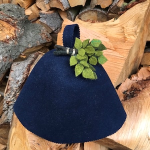 Peut inclure: Un chauffe-théière en feutre bleu foncé avec une fleur en feutre vert.