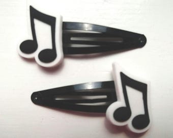 Puede incluir: Dos horquillas negras para el cabello con detalles de notas musicales blancas. Las notas musicales son negras con un borde blanco. Estos accesorios para el cabello ofrecen una forma sencilla pero elegante de incorporar un tema musical a cualquier peinado.