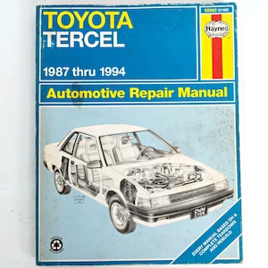 May include: A blue Haynes automotive repair manual for a Toyota Tercel, covering model years 1987 through 1994. The cover features a white line drawing of a car with an exposed engine and interior, along with the text 92085 (2106) and Haynes logo.