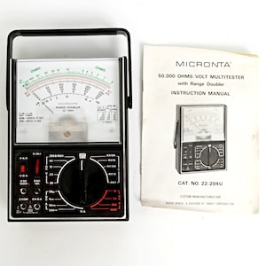 May include: A vintage Micronta multimeter with a black handle and face, featuring a needle gauge and various dials. The accompanying instruction manual reads "50,000 OHMS VOLT MULTITESTER" and "Range Doubler".