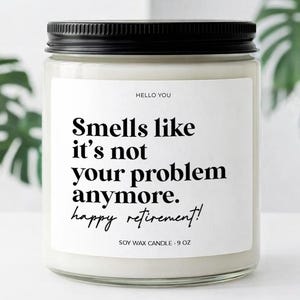 May include: A soy wax candle in a clear glass jar with a black lid. The label reads "Smells like it's not your problem anymore. happy retirement!" in black text. The candle is 9 oz.