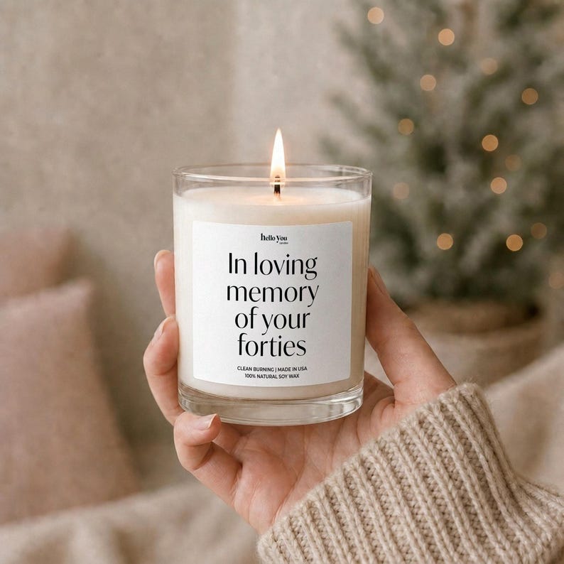 A hand holding a lit candle with a label that reads "In loving memory of your forties".