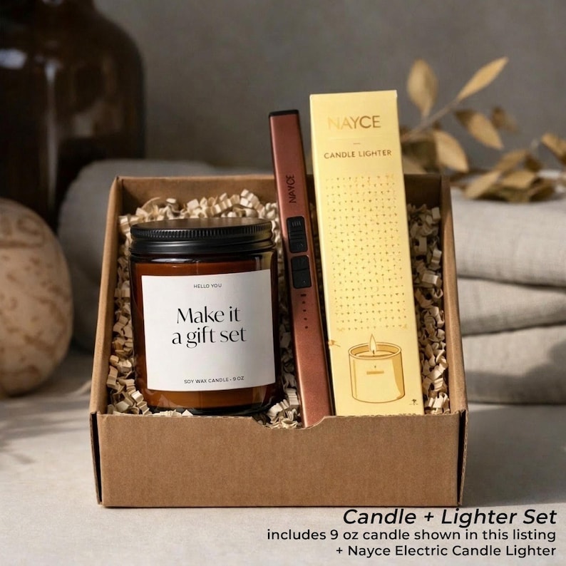 May include: A gift set in a cardboard box containing a soy wax candle, a copper-colored electric candle lighter, and a box of matches. The candle jar has a black lid and a label that reads "Make it a gift set". The lighter and candle are from the brand "Nayce".