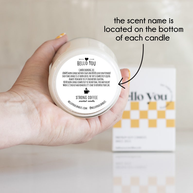 May include: A white candle jar with a black label that reads "HELLO YOU" and "STRONG COFFEE scented candle". The scent name is located on the bottom of each candle.