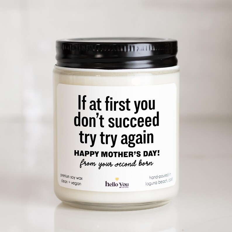 May include: A white candle with a black lid and a label that reads "If at first you don't succeed try try again Happy Mother's Day! from your second born". The candle is made with premium soy wax and is clean and vegan. It is hand-poured in Laguna Beach, California.