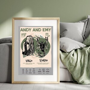 May include: A framed print featuring a Virgo and Scorpio zodiac design. The artwork includes illustrations of a woman and a scorpion, along with the names "Andy and Emy." The print is in a wooden frame and is displayed against a green wall.