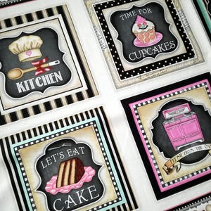 Pode incluir: Tecido preto e branco com tema de cozinha. O tecido apresenta quatro quadrados com imagens e texto diferentes. Os quadrados incluem um chapéu de cozinheiro com a palavra "Cozinha", um cupcake com o texto "Hora dos cupcakes", uma fatia de bolo com o texto "Vamos comer bolo", e um forno rosa com o texto "Recém-saído do forno".
