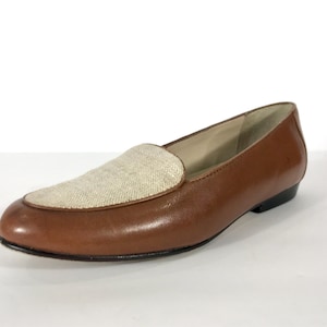 May include: Brown leather loafers with a beige canvas panel on the toe.