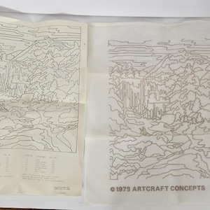 May include: Two vintage paint-by-number kits featuring a landscape scene with a waterfall and mountains. One is a printed guide with color codes, and the other is a canvas with the design outlined. The canvas has the text "©1979 ARTCRAFT CONCEPTS 871053".