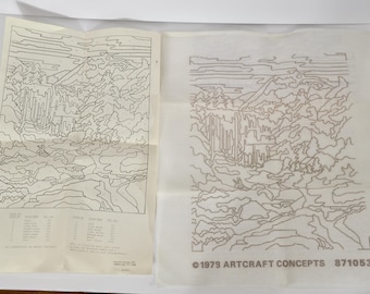 May include: Two vintage paint-by-number kits featuring a landscape scene with a waterfall and mountains. One is a printed guide with color codes, and the other is a canvas with the design outlined. The canvas has the text "©1979 ARTCRAFT CONCEPTS 871053".