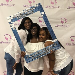 May include: Three women are posing for a photo with a blue denim photo booth prop. The prop has the text "Better Woman Fellowship" and "I have those JEANS #seeyourselfbetter".