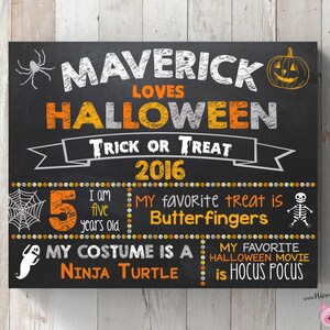 以下が含まれることがあります： オレンジと白の文字で、マヴェリックがハロウィーンを愛していることを発表している、黒いチョークボードの看板。看板には、彼の好きなお菓子、コスチューム、ハロウィーン映画についての詳細が記載されています。看板には2016年も記載されています。