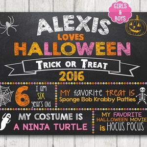 以下が含まれることがあります： オレンジとピンクの文字で「アレクシスはハロウィーンが大好き！トリックオアトリート 2016」と書かれた黒いチョークボードの看板。看板には、子供の年齢、好きなお菓子、ハロウィーンのコスチュームに関する情報も記載されています。