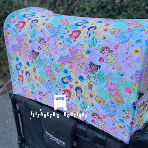 May include: A black wagon with a white and purple fabric canopy featuring a pattern of Disney princesses. The canopy has the text "Elizabeth's Boutique" printed on it. The wagon has a black Wonderfold Wagon logo on the side.