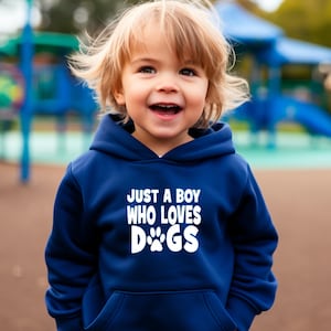 May include: A young child wearing a navy blue hoodie with a white graphic that says "Just a boy who loves dogs" with a paw print in the word dogs.