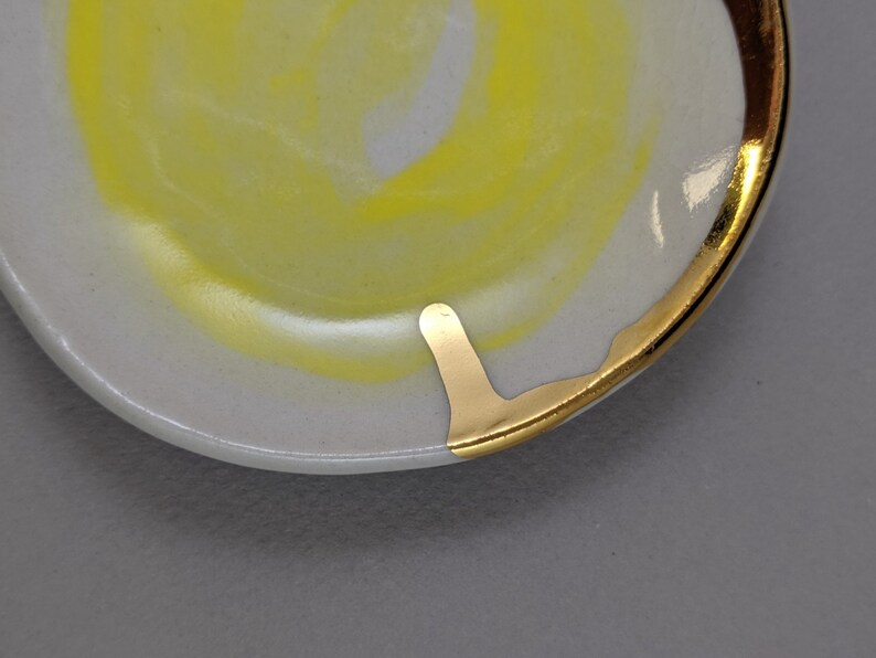 small jewelry dish with bright yellow design and 22k gold embellishments