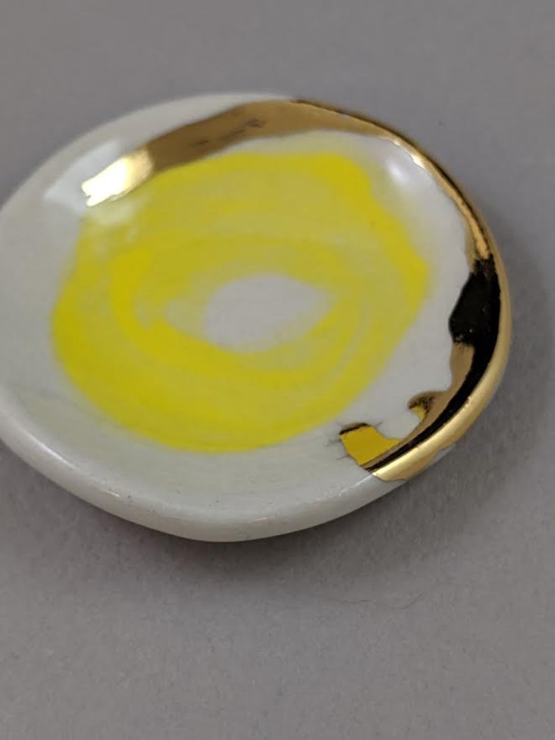 small jewelry dish with bright yellow design and 22k gold embellishments