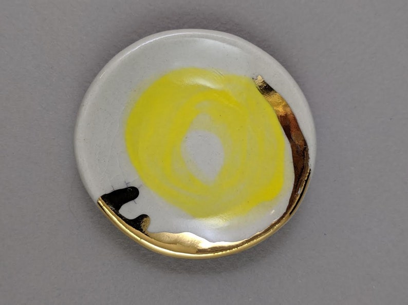 small jewelry dish with bright yellow design and 22k gold embellishments