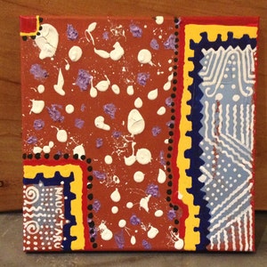 May include: Square canvas art with a textured, abstract design. The artwork features a reddish-brown background with white splatters and purple accents. Bold borders in yellow, blue, and red frame the design, with the text "NAUCY TARU" visible.