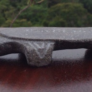 May include: A gray stone turtle sculpture with a flat top. The turtle is carved with intricate details and has a smooth, polished finish.