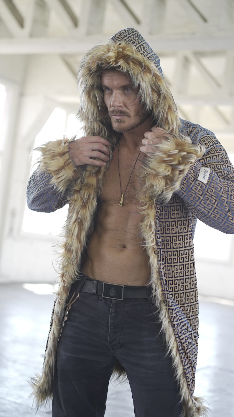 May include: A blue and gold patterned faux fur hooded coat with a black belt. The coat has a geometric pattern and a long, flowing style.