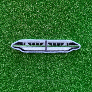 May include: A white and green embroidered patch of a monorail train on a green glitter background.