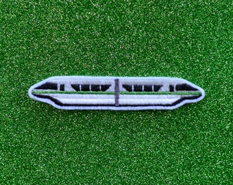May include: A white and green embroidered patch of a monorail train on a green glitter background.