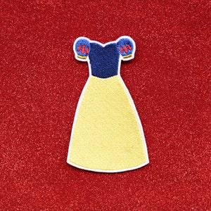 May include: A yellow and blue embroidered dress patch with a white outline. The dress has a blue bodice and yellow skirt with puffed sleeves.