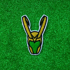 May include: Green and gold embroidered iron-on patch of Loki's helmet from the Marvel comics and movies.