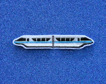 May include: A white and blue embroidered patch of a monorail train. The train has a dark gray stripe running along the side and a light blue stripe running along the bottom.
