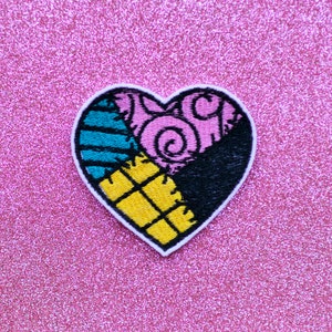 May include: Heart-shaped embroidered patch with a white border. The patch is divided into four sections: teal stripes, pink swirls, black, and yellow squares. The patch is on a pink glitter background.
