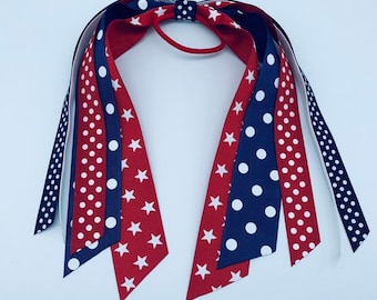 May include: Red, white and blue ribbon hair tie with a polka dot and star pattern.