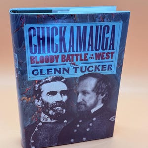 May include: A hardcover book titled "Chickamauga Bloody Battle in the West" by Glenn Tucker. The cover features portraits of two men in military uniforms and a blue and red title design against a dark, textured background.
