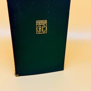 May include: A dark green book with gold accents and the text "MODERN LIBRARY" and "BC" in a gold emblem. The book is standing upright, with a slightly angled view, showcasing its cover and spine.