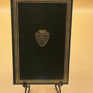 May include: A white ceramic mug with a black handle and the text "But First, Coffee" in a black, handwritten-style font. The mug is on a white surface.