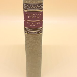 May include: A hardcover book titled "Gulliver's Travels" by Jonathan Swift. The spine is light green with a burgundy label featuring the title and author's name. The book is part of the Classics Club series.