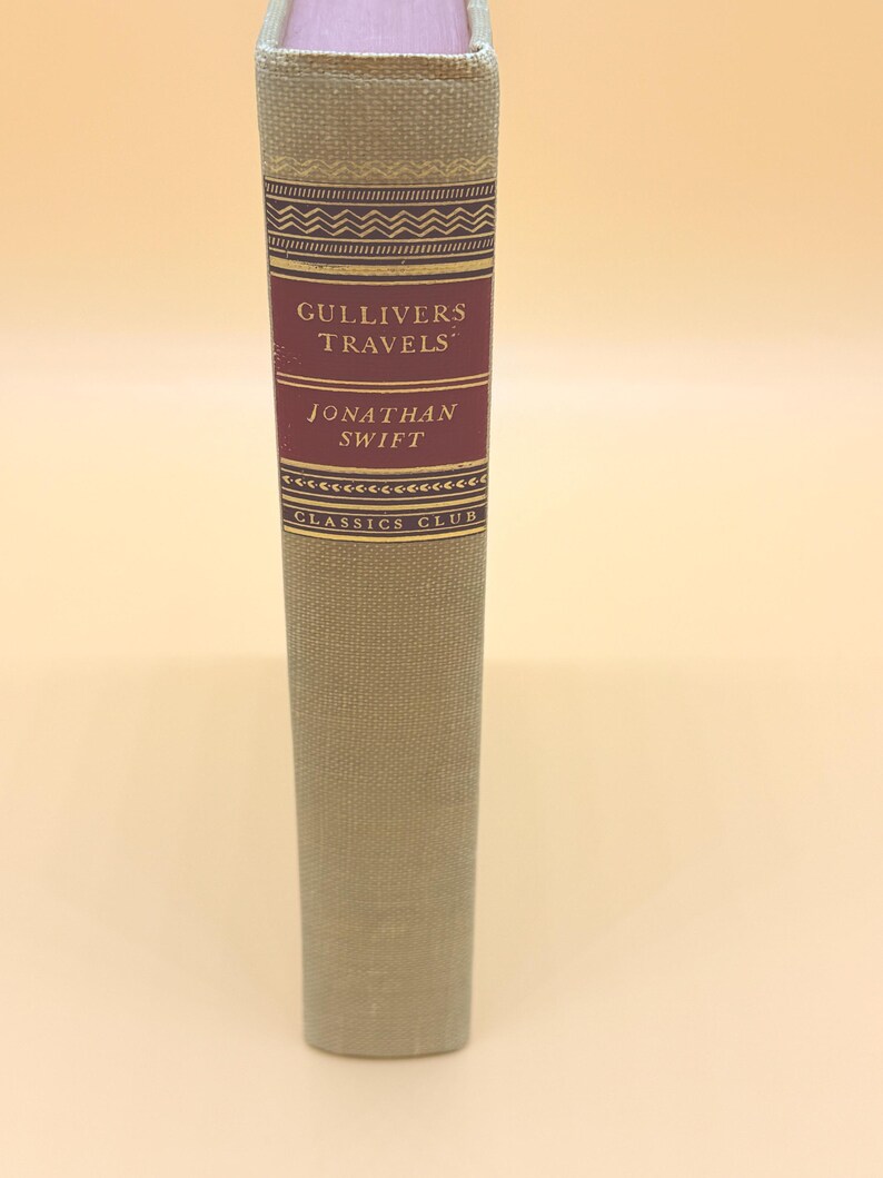 May include: A hardcover book titled "Gulliver's Travels" by Jonathan Swift. The spine is light green with a burgundy label featuring the title and author's name. The book is part of the Classics Club series.