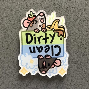 Pode incluir: Uma placa verde e azul com as palavras "Dirty Clean" nela. Um rato de desenho animado com uma banana e um morango na cabe&ccedil;a est&aacute; segurando a placa. Outro rato de desenho animado est&aacute; pendurado de cabe&ccedil;a para baixo abaixo da placa.