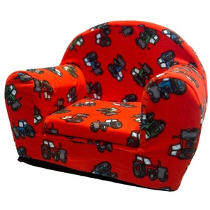 Puede incluir: Sill&oacute;n rojo para ni&ntilde;os con tejido estampado de tractores. El sill&oacute;n tiene un asiento y un respaldo acolchados.