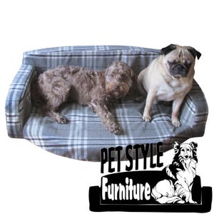 Puede incluir: Dos perros relajándose en una cama para perros de color gris y blanco a cuadros. La cama tiene un respaldo elevado y un frente redondeado. El texto "PET STYLE Furniture" es visible en la esquina inferior derecha de la imagen.