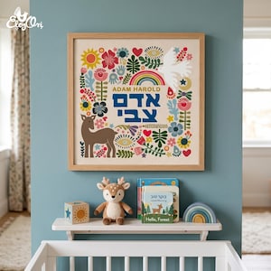 May include: A framed print with a floral and deer design, featuring the name "ADAM HAROLD" in English and Hebrew. Below, a shelf holds a stuffed deer, wooden block, books, and a rainbow-shaped toy. The color scheme includes blues, greens, and browns.