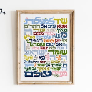 Könnte beinhalten: Gerahmter Kunstdruck mit farbenfrohem hebräischen Text in verschiedenen Schriftarten und -größen. Der Text ist in einer optisch ansprechenden Komposition angeordnet, mit einer Mischung aus Blau-, Grün-, Gelb- und Rosatönen. Das Kunstwerk befindet sich in einem hellbraunen Holzrahmen.