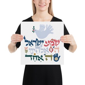 May include: A white poster with a blue dove holding a green branch with a red flower. The poster features Hebrew text and colorful illustrations, including a pink heart, a red pomegranate, a yellow sun, a blue hand with a hamsa symbol, and a blue eye. The text reads "Shalom Aleichem" and "Peace be with you".