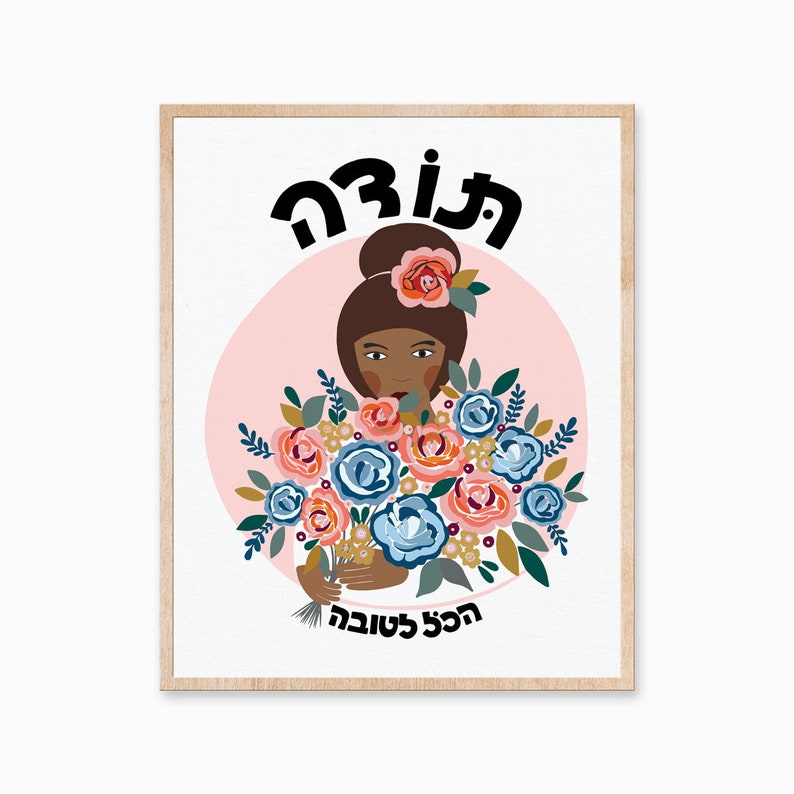 May include: A framed print with a pink background and a woman with brown hair and a floral crown holding a bouquet of blue and pink flowers. The text "The Good" is at the top of the print and the text "The Good Life" is at the bottom.