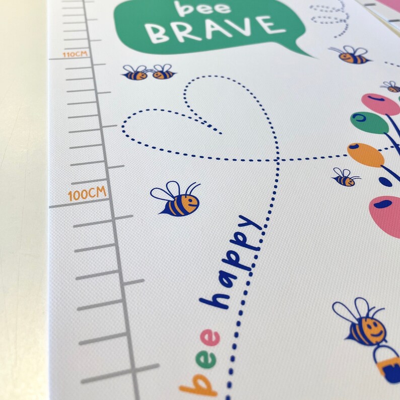 May include: A white growth chart with a green speech bubble that says "bee BRAVE". The chart features a dotted heart, bees, and the words "bee happy". Measurements are in centimeters.