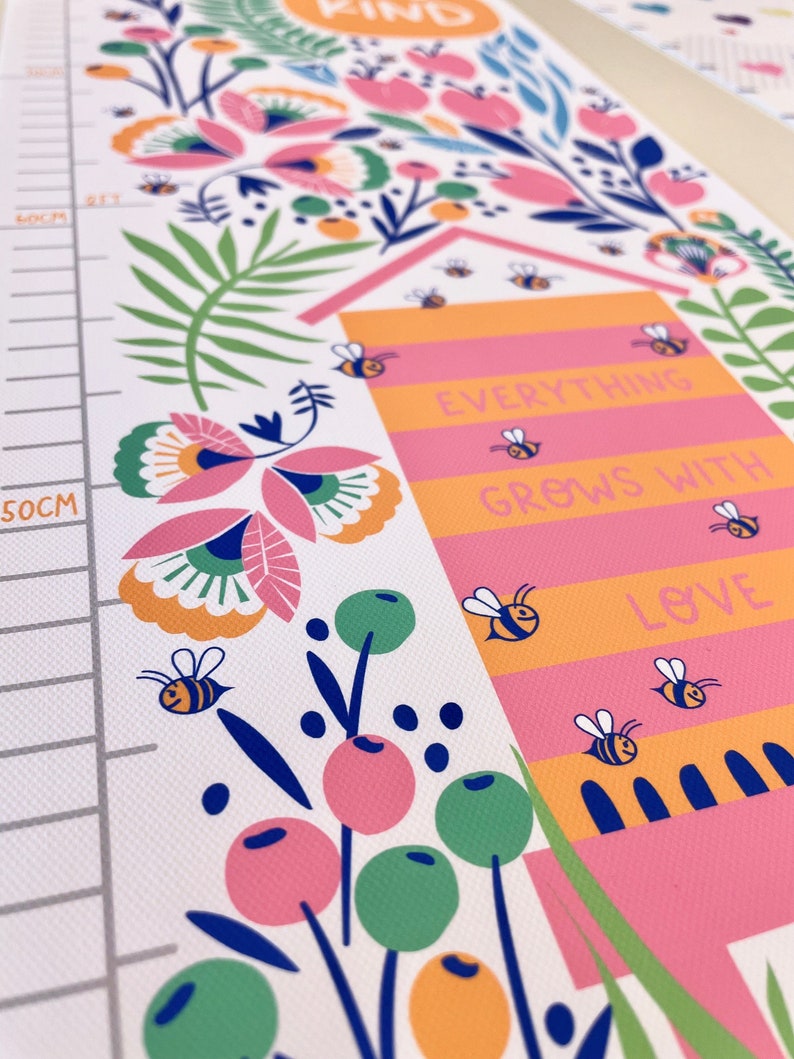 May include: A colorful height chart with floral and bee illustrations. The chart features the words "Everything Grows With Love" and "Kind". The design includes a measurement scale in centimeters.